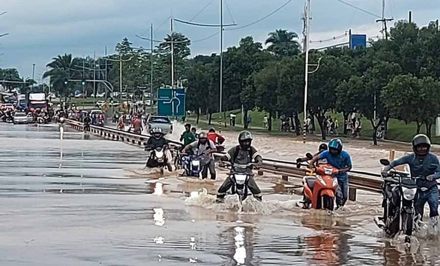 Motoristas e pedestres se arriscam para atravessar em rodovia alagada em Rio Branco