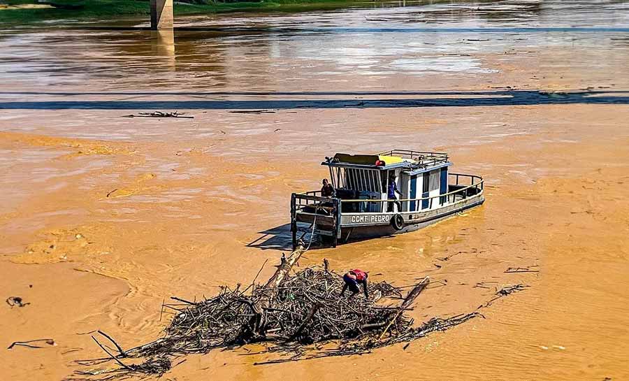 Com Rio Acre próximo dos 12 metros, balseiros se acumulam em pontes e equipes do Deracre fazem limpeza